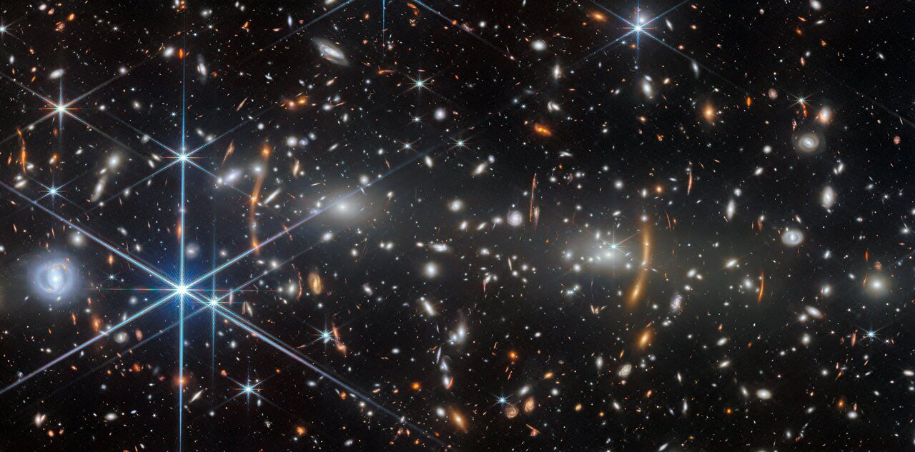 A vibrant cosmic scene with swirling galaxies and bright stars forming a celestial structure.