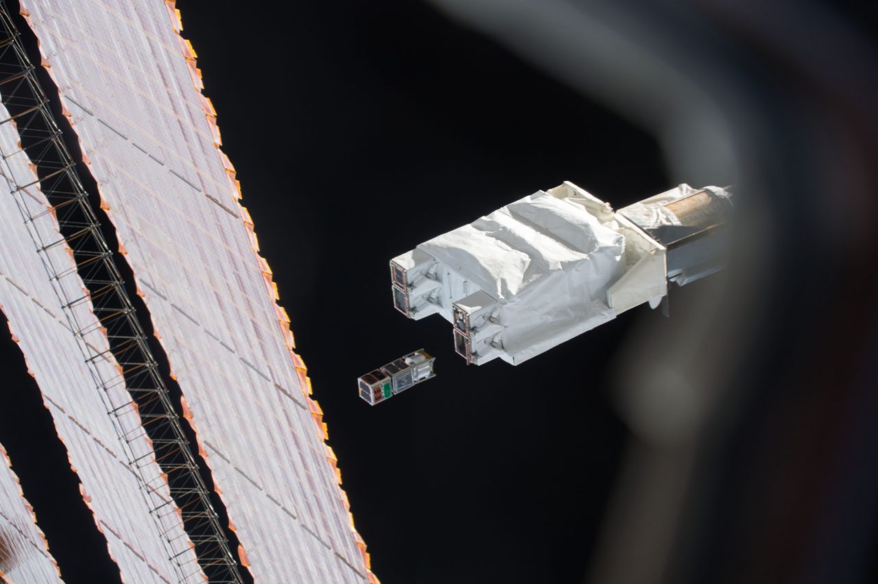 J-SSOD-6 satellite deployment from space station with Earth in background.