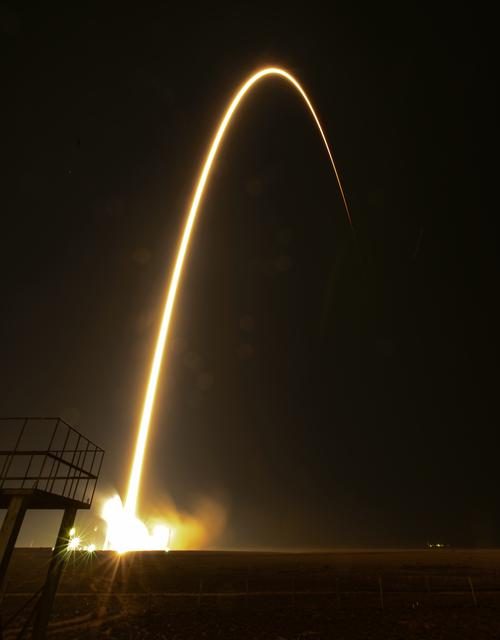 Nighttime launch of Expedition 39 rocket with bright flames against dark sky.