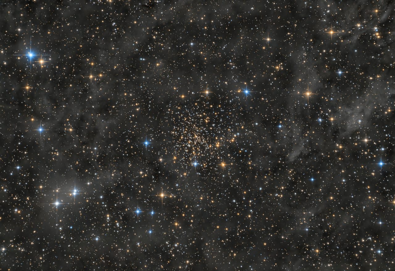 A dense star cluster, NGC 188, featuring numerous bright stars against a dark space background.