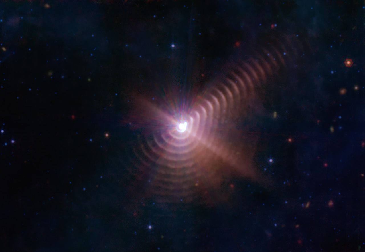 Dust rings formed by stellar winds in Wolf-Rayet 140, captured by NASA's James Webb Space Telescope.