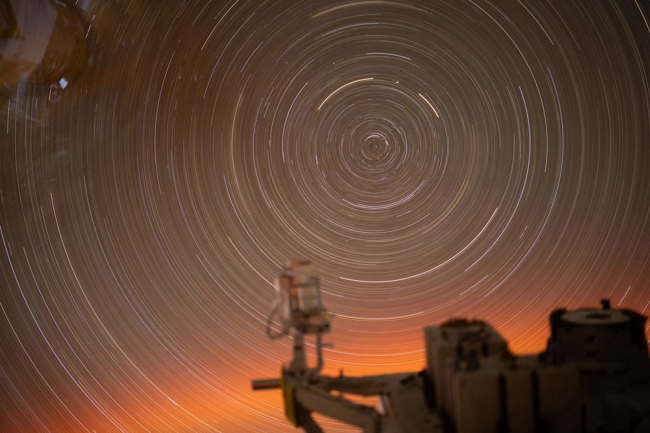 Circular star trails seen from the International Space Station above Earth's glowing horizon